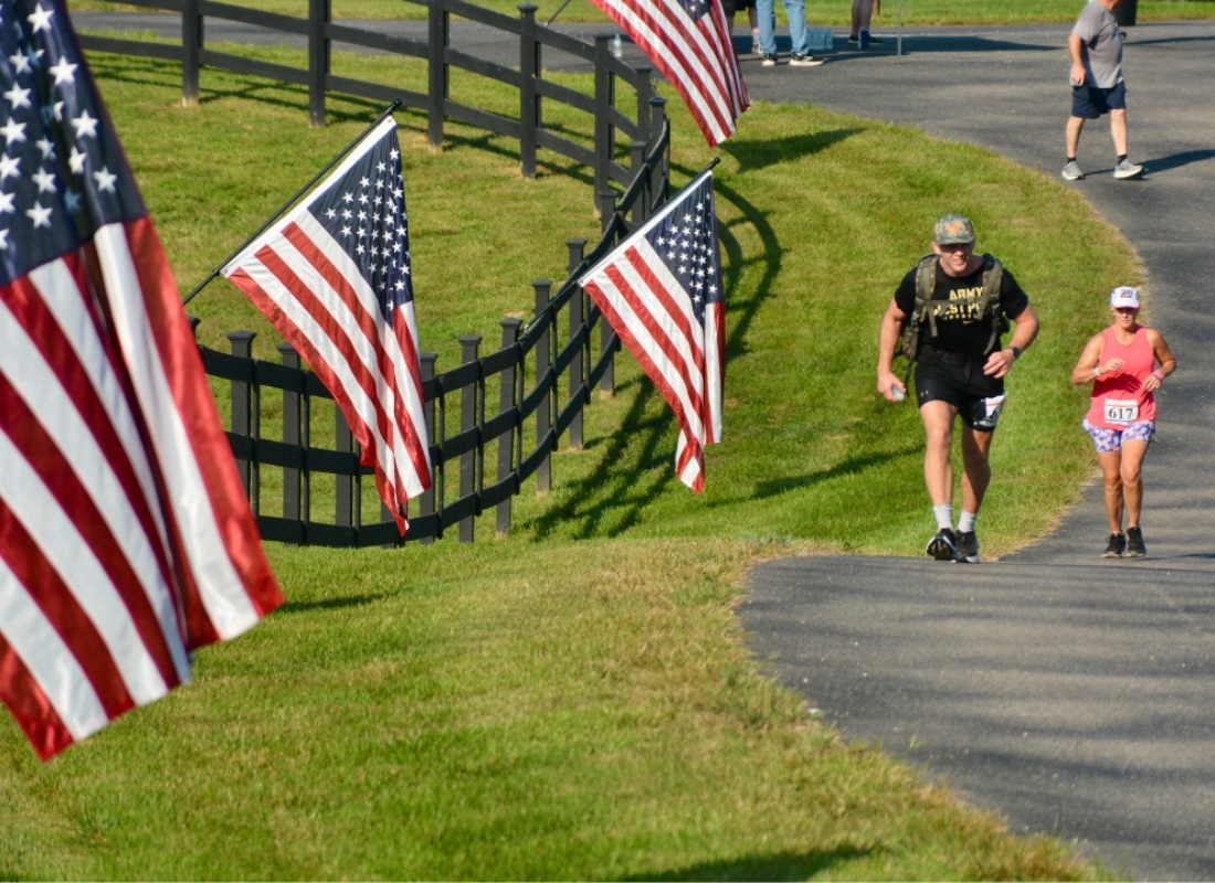 honor run man running with american flag and ruck run for ofs in huntingburg indiana at Cool Springs