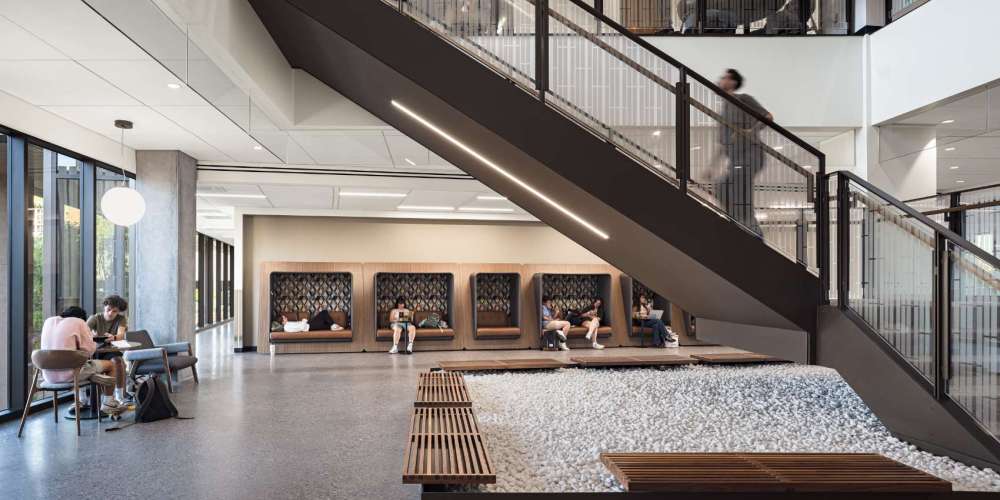 Students sitting and studying along the wall in an university setting