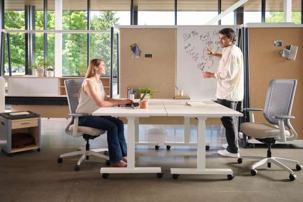 Kaleid workstation enabling collaboration with shared table, marker board, and integrated storage in an adaptable workplace