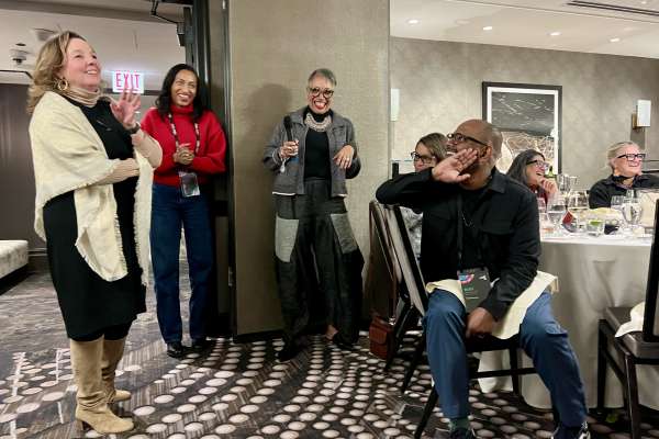 Design professionals engaging in conversation during informal gathering at industry event