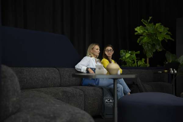 Two women sitting on OFS Obee while talking at ICFF 2026.