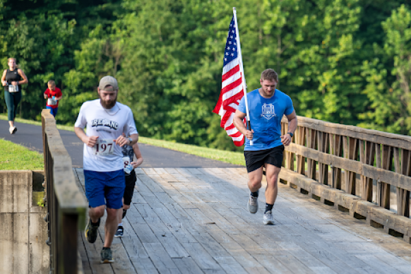 men-jogging-with-american-flag-honor-and-remember-run