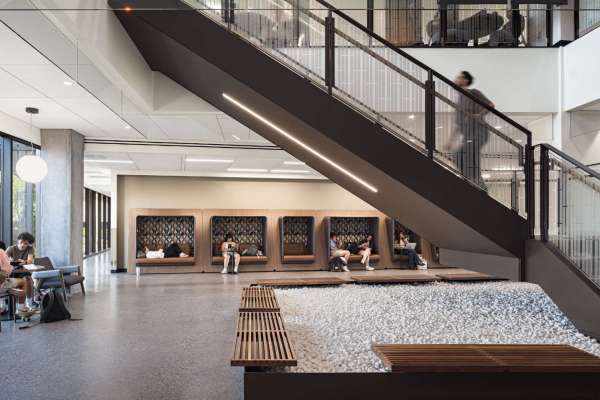 Students sitting and studying along the wall in an university setting